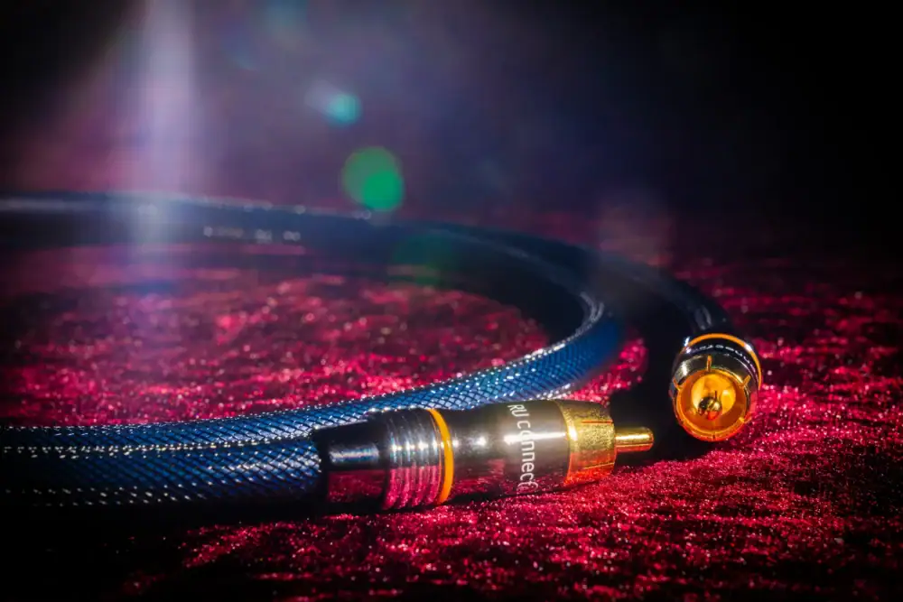 subwoofer-kabel-rode-achtergrond RCA-connectoren van de subwoofer kabel op een rode ondergrond.
