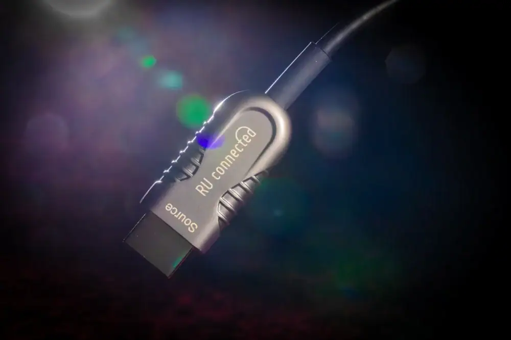 ru-connected-optische-hdmi-2-1-connector-bokeh Source-connector van de optische HDMI 2.1 kabel met gekleurde achtergrond